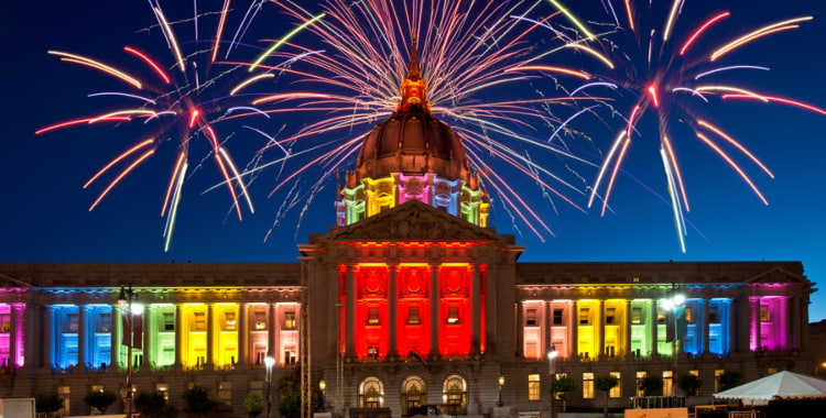 fireworks burst behind a rainbow san francisco city hall