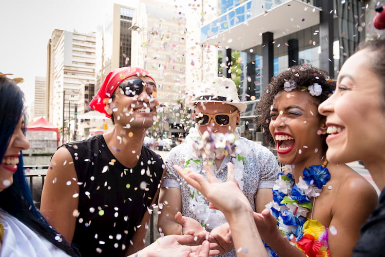 friends throw confetti during carnaval san francisco