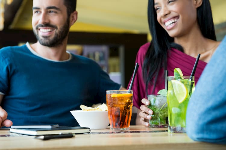 Two people with cocktails at happy hour