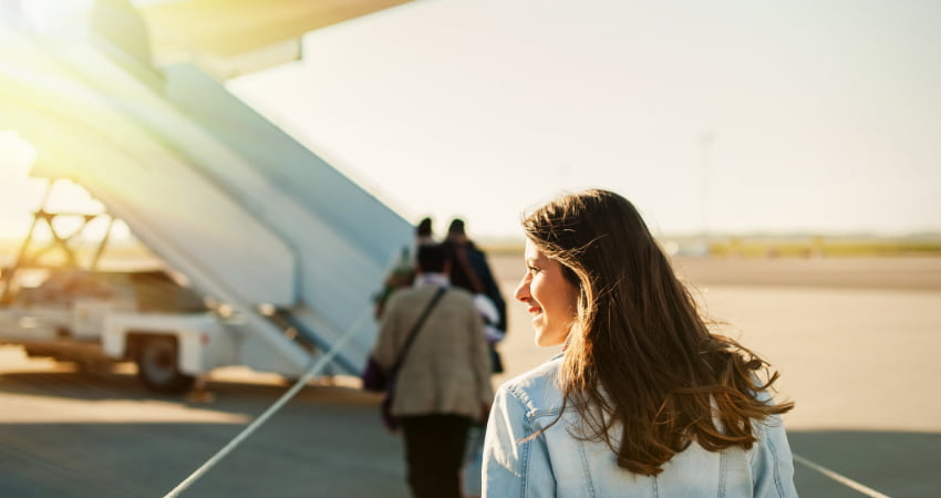 A woman boards a plane from an outdoor ramp