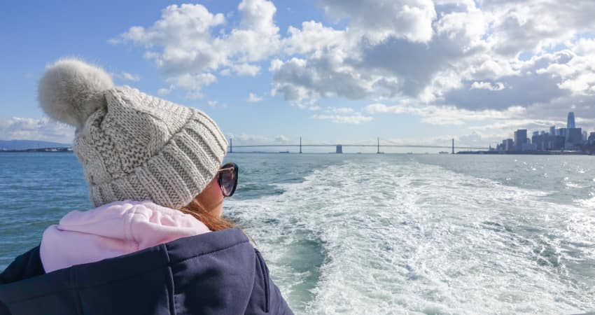 A passenger in a winter cap rides the ferry between Alcatraz and the San Francisco mainland