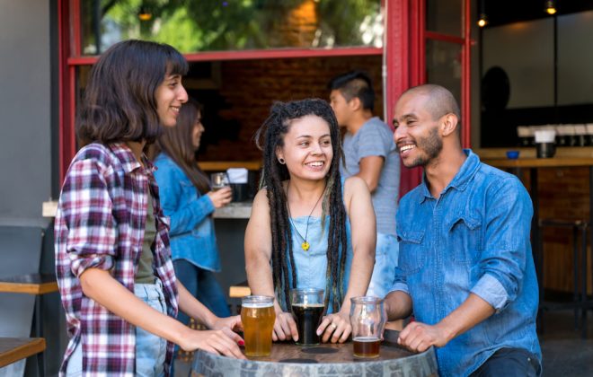 Friends around barrel table at brewery