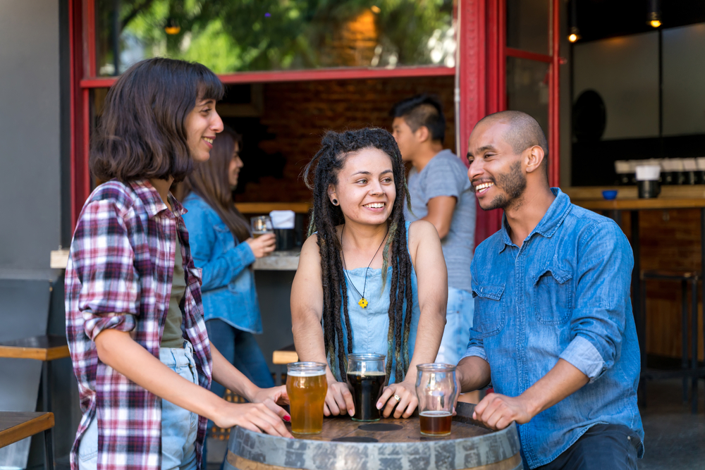 Friends around barrel table at brewery