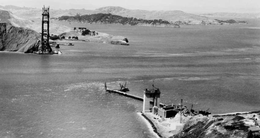 A black and white photo from 1932 as the Golden Gate Bridge is being constructed across the bay