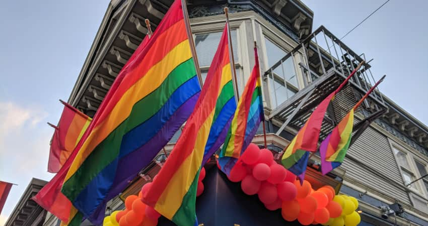 Rainbow flags and balloons hang outside a building in San Francisco