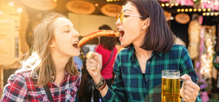 two friends share a hot dog