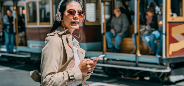 A woman stands in front of a cable car in San Francisco